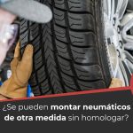 Hombre montando un neumático de diferente tamaño en su coche